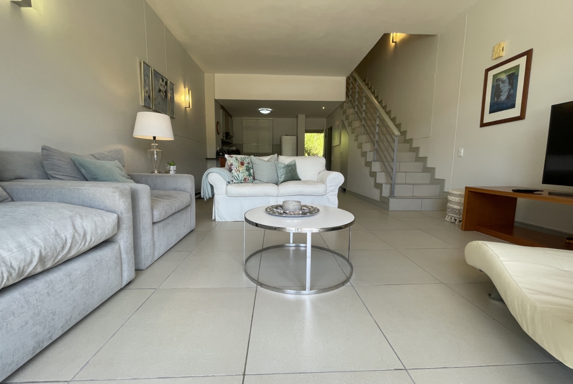 Open plan living area with stairs leading to bedrooms on second floor